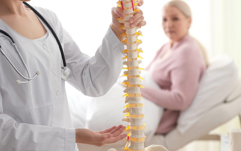 blonde woman with doctor holding spine