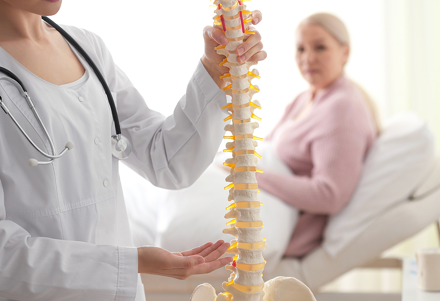 blonde woman with doctor holding spine