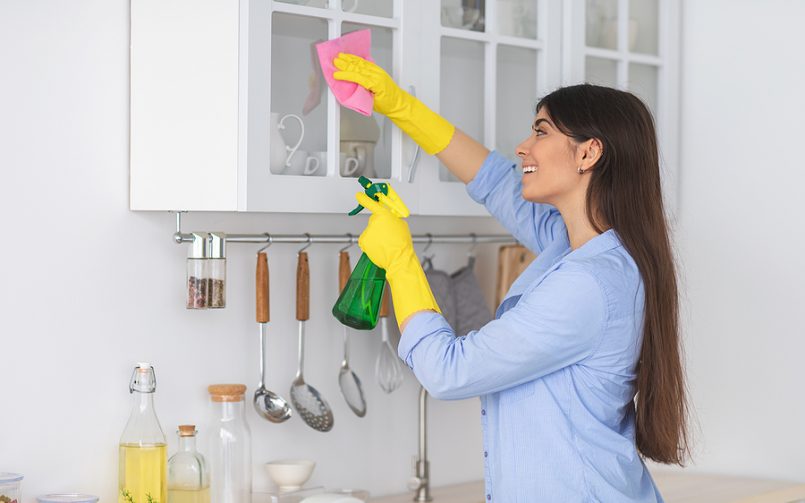 young woman smiling cleaning shelves