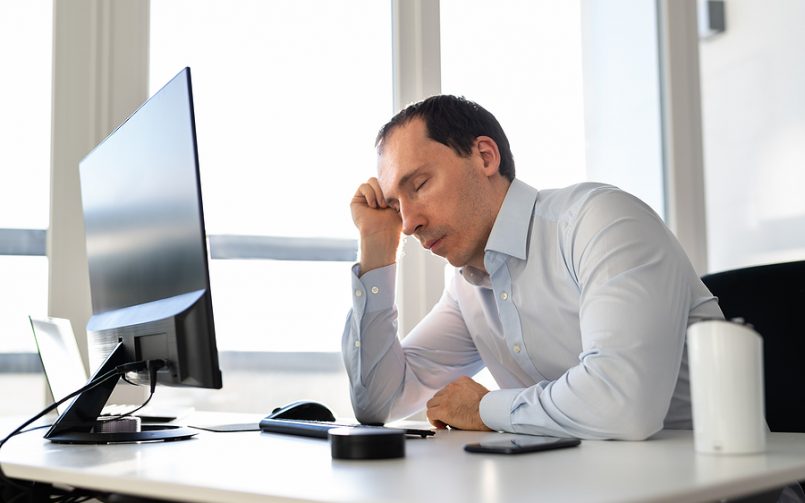 mid age man tired at desk