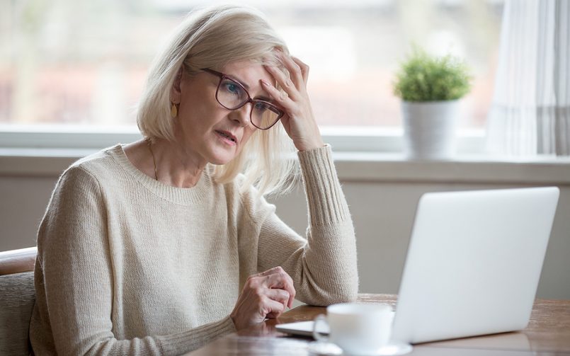 mature woman white hair looking at computer
