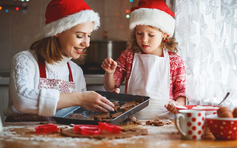 mother and daughter baking Christmas cookies in kitchen