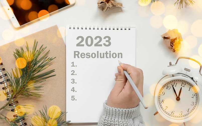 hand writing new year resolutions in notebook